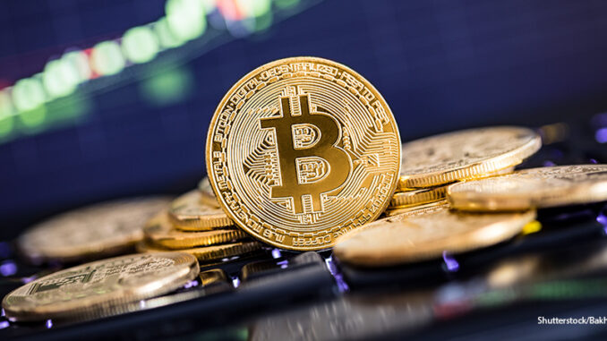 102218_02P_FS Bitcoin gold coin and defocused chart background. Virtual cryptocurrency concept