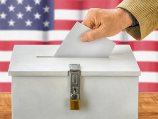 Man putting a ballot into a voting box – USA