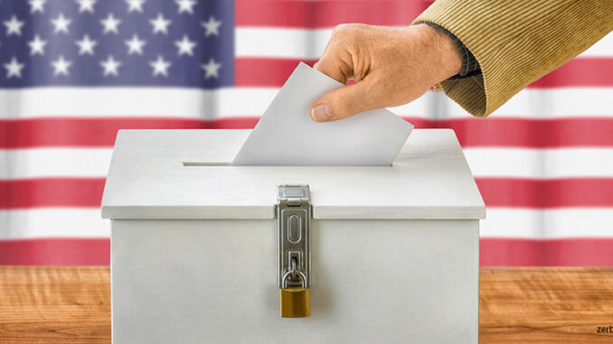 111918_01P_FS Man putting a ballot into a voting box – USA