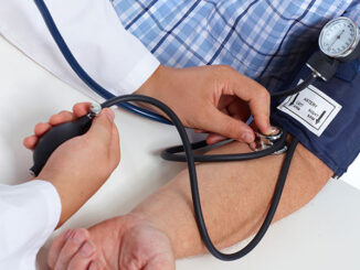 Doctor checking old man patient arterial blood pressure.