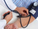 Doctor checking old man patient arterial blood pressure.