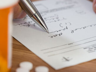 Close up of man filling out prescription
