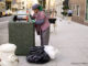 Homeless person at public trash can