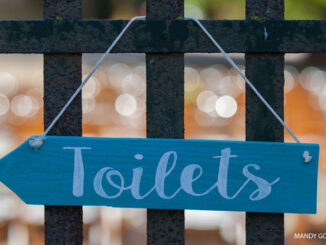 Sign of toilet on fence