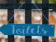 Sign of toilet on fence