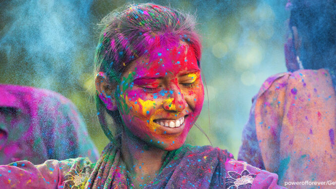 Young Woman Enjoying Holi Festival Young woman covered in colored dye enjoying Holi festival in Jaipur, India.