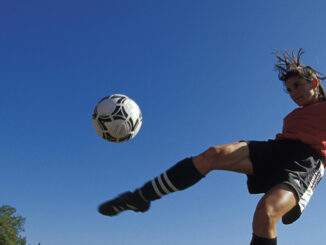 woman kicking soccer ball