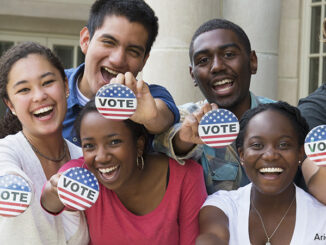 Students holding buttons at voter registration