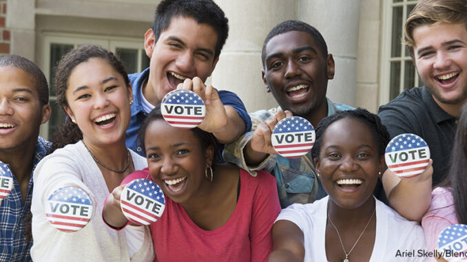Students holding buttons at voter registration Students holding buttons at voter registration
