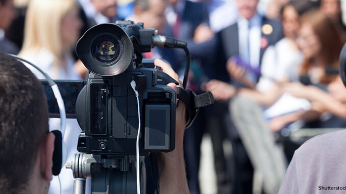 Filming an media event with a video camera. Press conference.