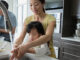 Mother and daughter washing hands in kitchen sink