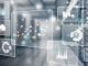 floating graphics representing data analytics over a greyed image of a computer server room