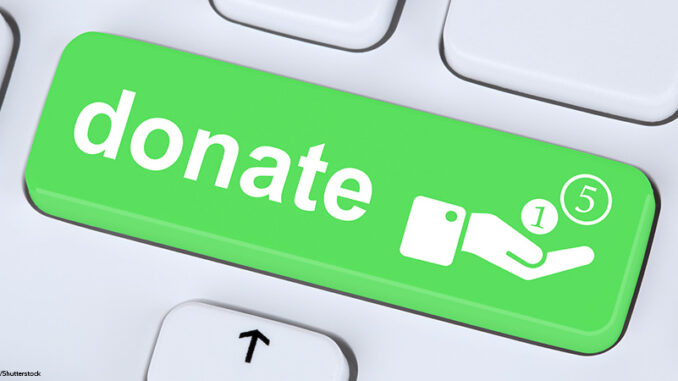 Donate money donation for a project symbol on computer keyboard Close-up view of a button on a computer keyboard with the word 'donate' and a hand symbol with coins
