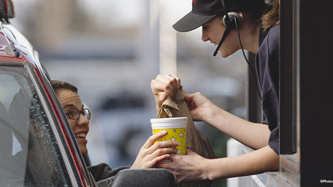 a fast-food employee gives a customer her order a fast-food employee gives a customer her order