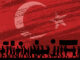 silhouetted image of marching protesters with signs in front of a full background image of the Turkey national flag