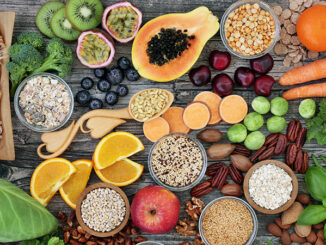 High dietary fibre health food concept with fruit, vegetables, whole wheat pasta, legumes, cereals, nuts and seeds
