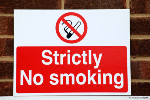 No smoking sign attached to red brick wall