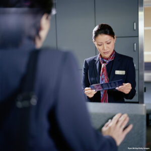 person waiting in line at airport check-in desk