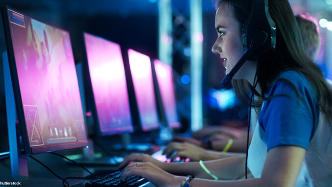Team of Professional eSport Gamers Playing Competitive MMORPG/ Strategy Video Game on a Cyber Games Tournament. They Talk to Each other into Microphones. Arena Looks Cool with Neon Lights. A young woman wearing a headset and playing competivie video games in a tournament.