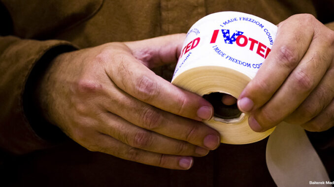 I voted stickers being passed out to people at a polling station I voted stickers being passed out to people at a polling station