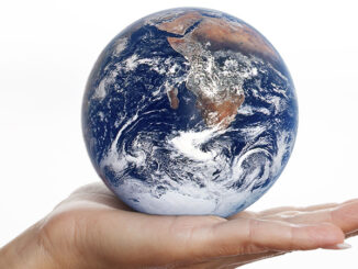 Globe earth glass ball in human hand isolated on white