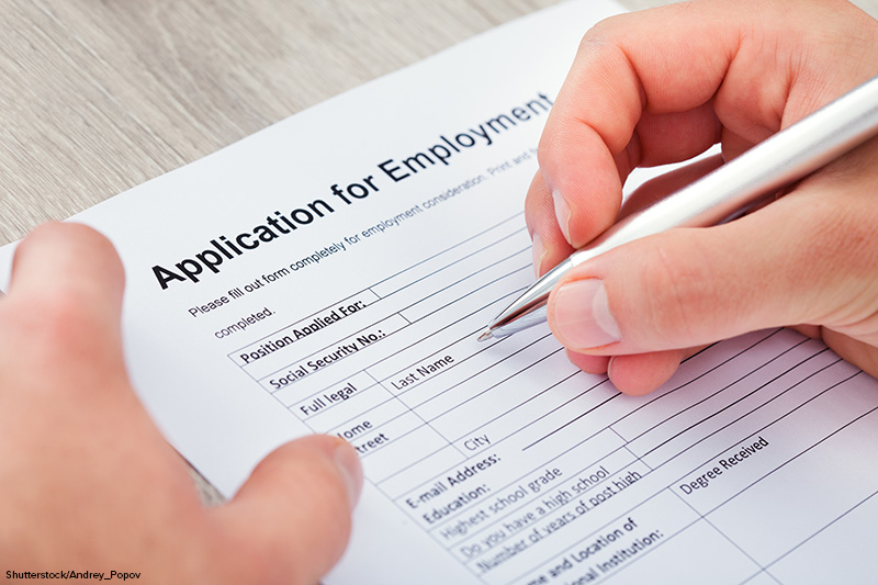 Close-up Of Hand Filling Application For Employment