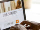 African man browsing work opportunities online using job search computer app,