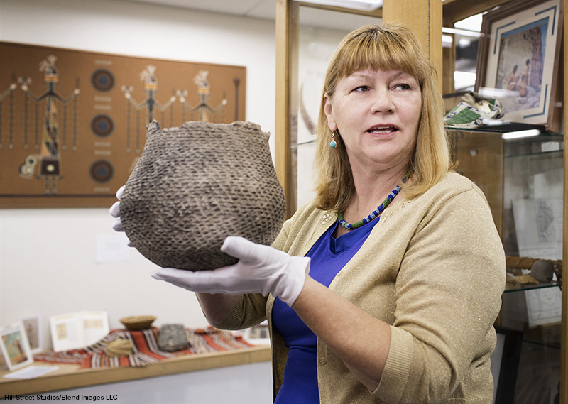 curator holding artifact in museum