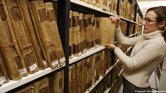 Librarian in Palacio de Cervello, Valencia, Spain female librarian selecting an old manuscript