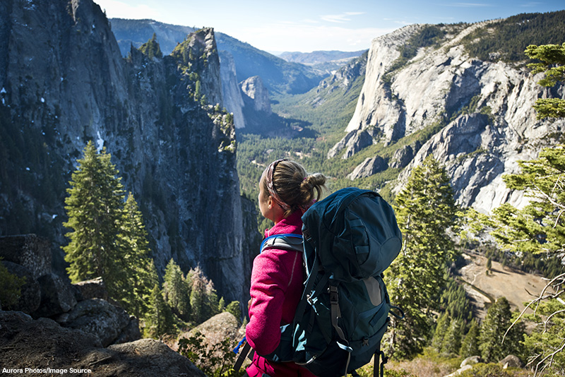 female backpacker stops to take in the views of Yosemite National Park