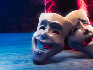 Theater masks, drama and comedy with a red curtain as backdrop