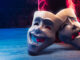 Theater masks, drama and comedy with a red curtain as backdrop