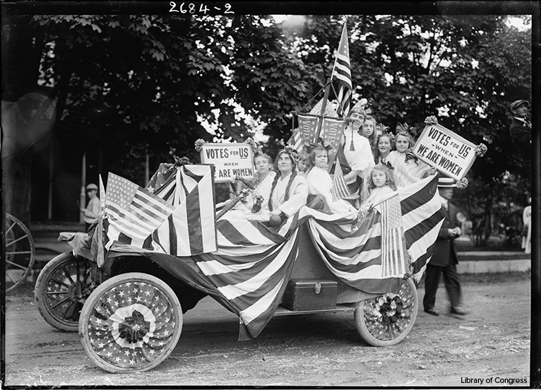 woman suffragettes in parade car