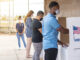 Young voters casting their ballots outdoors, wearing masks