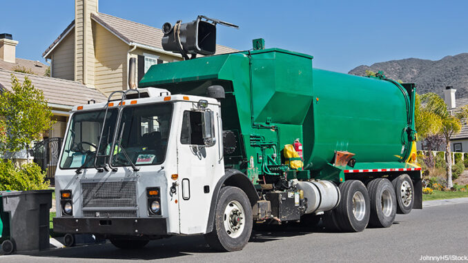 Garbage Day Pickup Garbage truck emptying a trash bin in front of a house.