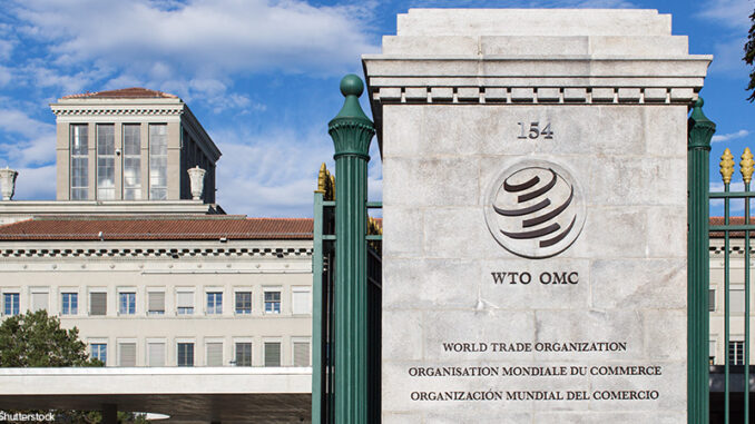 GENEVA, SWITZERLAND - SEPTEMBER 7, 2014: The World Trade Organization. The WTO deals with the global rules of trade and is hosting new negotiations under the Doha Development Agenda. front gate and sign for The World Trade Organization (WTO) headquarters