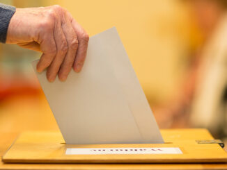 Man throws ballot papers into ballot box