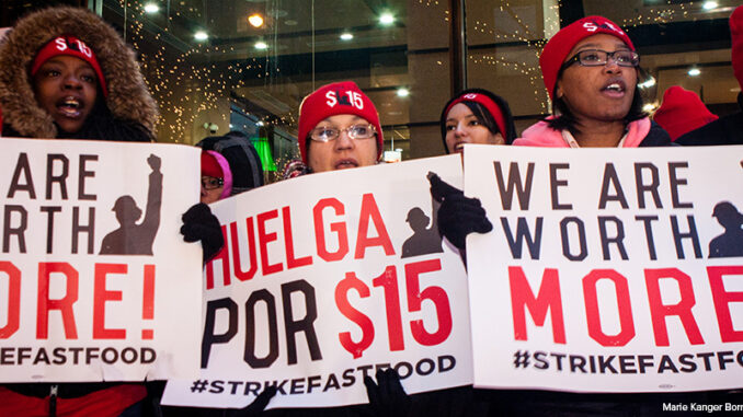 low-wage workers holding up signs at a rally to advocate for better wages