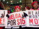 low-wage workers holding up signs at a rally to advocate for better wages
