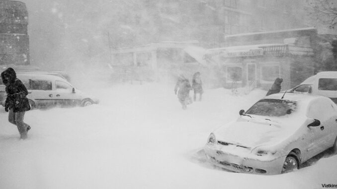 Winter disaster in a city Street scene of a winter blizzard with people walking about in a city