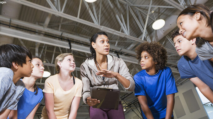 Group of children with coach in school gym Group of children with coach in school gym