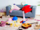 toys scattered around a room in front of a couch