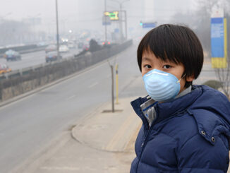 Boy in Beijing China wearing mouth mask against air pollution