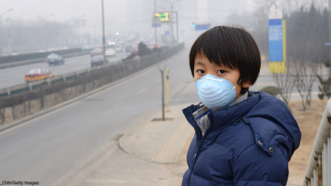 Asian boy wearing mouth mask against air pollution (Beijing) Boy in Beijing China wearing mouth mask against air pollution