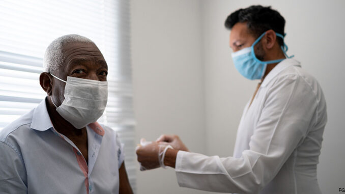 Portrait of patient getting vaccination using face mask Portrait of African American male patient getting vaccination using face mask