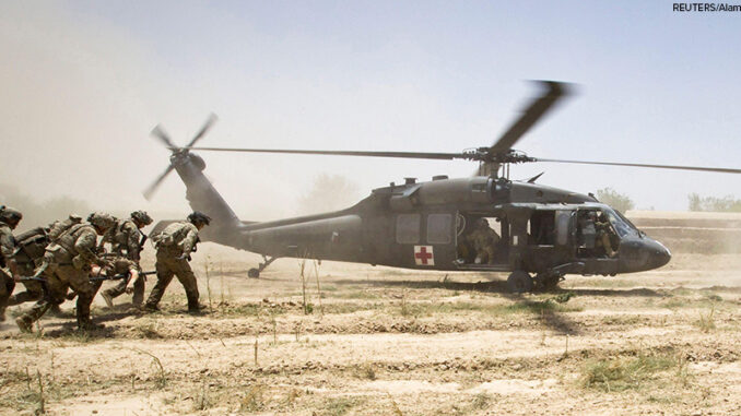 U.S. Army soldiers carry Sgt. Matt Krumwiede, who was wounded by an improvised explosive device (IED), towards a Blackhawk Medevac helicopter in southern Afghanistan in this June 12, 2012 file photo. On June 12, 2012, Krumwiede was on patrol in Afghanista U.S. Army soldiers move towards a Medevac helicopter in southern Afghanistan