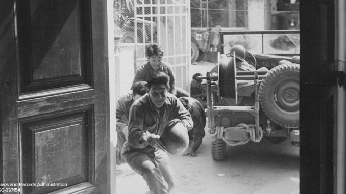 Americans of Japanese descent, Infantrymen of the 442nd Regiment, run for cover as a German artillery shell is about to land outside the building. Italy. 4 April 1945. Americans of Japanese descent, Infantrymen of the 442nd Regiment,