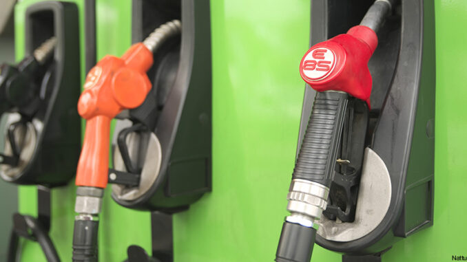 Shallow DOF of E85 nozzle hanged on vivid color gas station gasoline pumps at a gas station