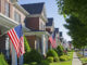 American Flags hang from the front of this traditional, brick homes