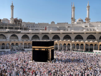 view of a crowd of praying Muslim pilgrims from all around the world revolving around the Kaaba